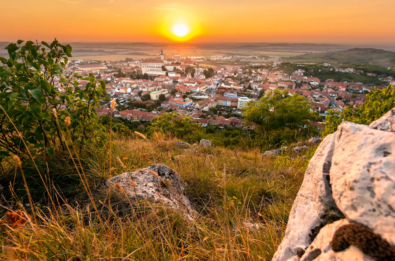 Vidina na město Mikulov při západu slunce z kopce.