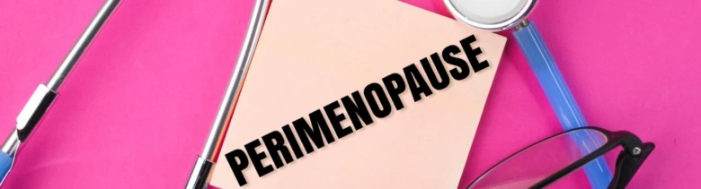 Nápis perimenopauza s lékařskými nástroji na růžovém pozadí.