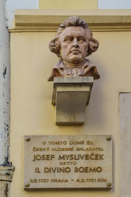 Bronzová socha Josefa Myslivečka s pamětní deskou v Praze.