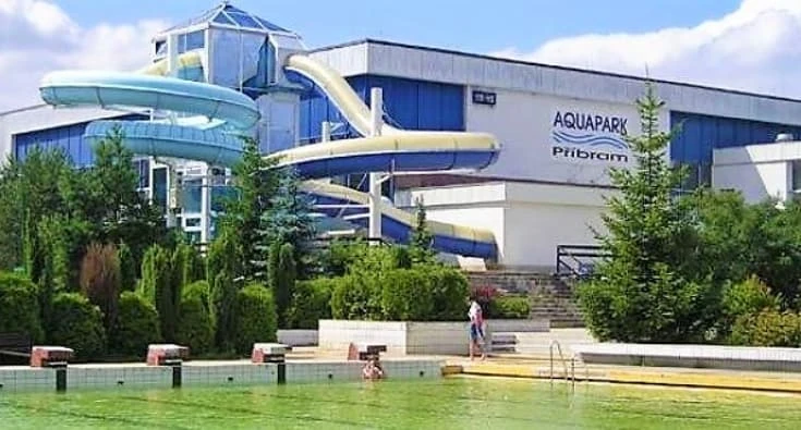 Vodní park v Příbrami s barevnými skluzavkami a bazénem.