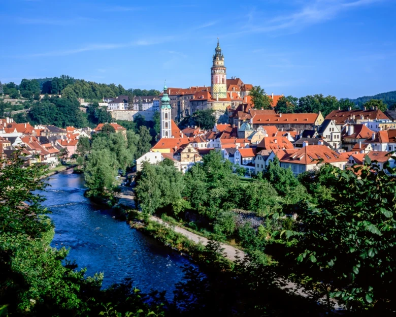 Historické město s hradem na kopci a řekou v Čechách.