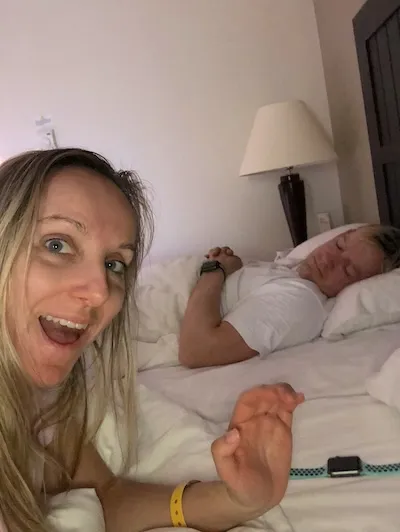 Žena se fotí s telefonem v hotelovém pokoji.