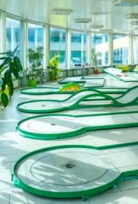Indoor mini golf hřiště s zelenými dráhami v Praze.