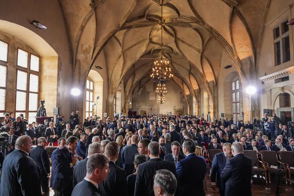 Velká skupina lidí v oficiálním sále během události.