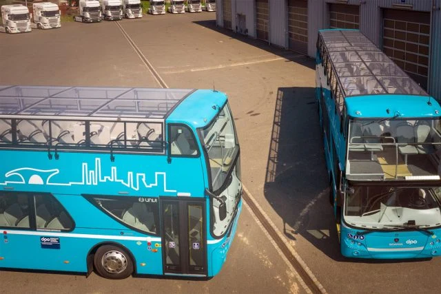 Dva modré dvoupodlažní autobusy na parkovišti v depu.