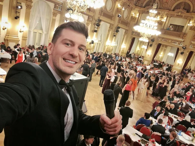 Muž s mikrofonem na slavnostní akci v zámku