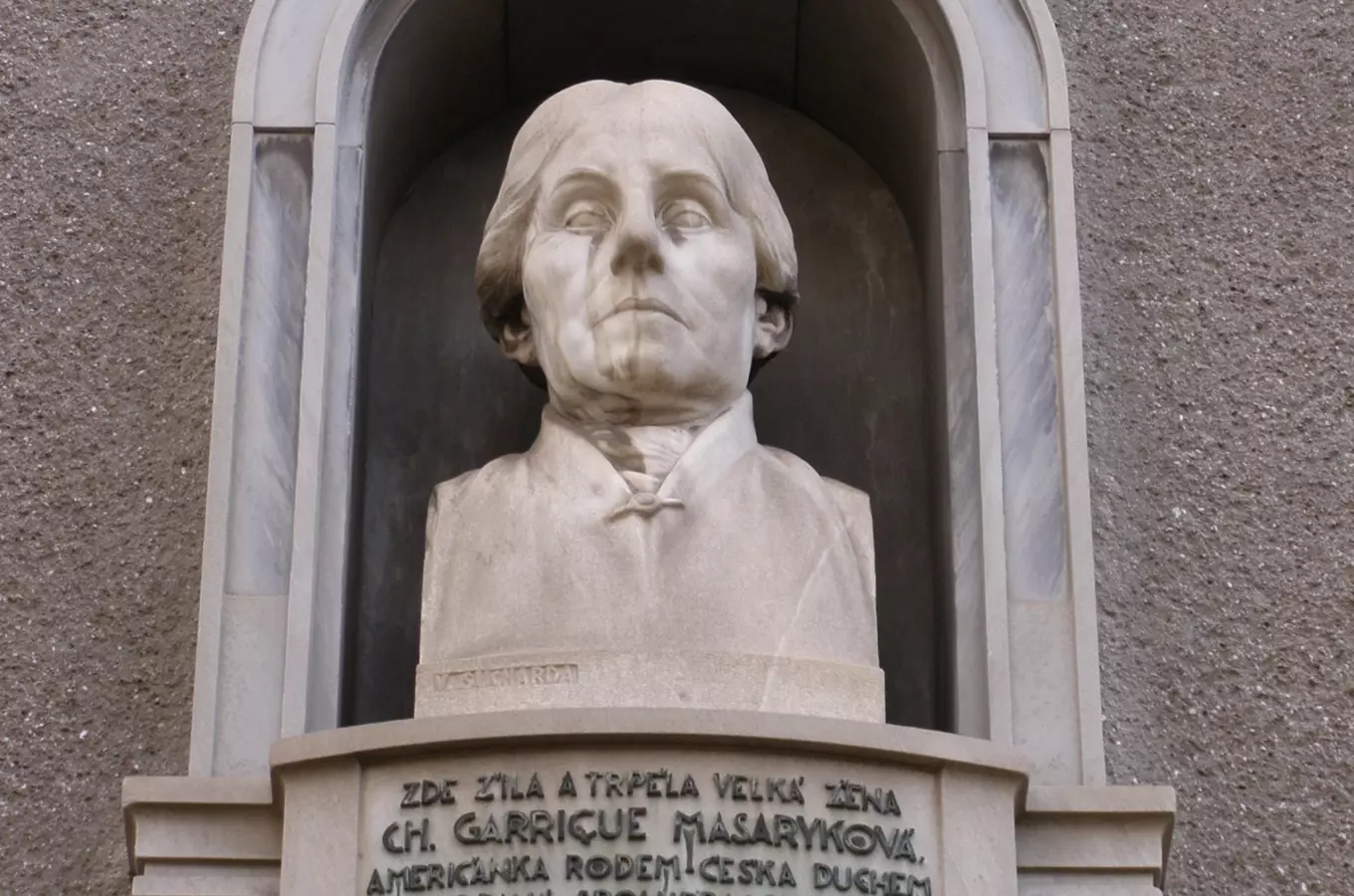Mramorová socha Charlotty Garrigue Masarykové na fasádě budovy.