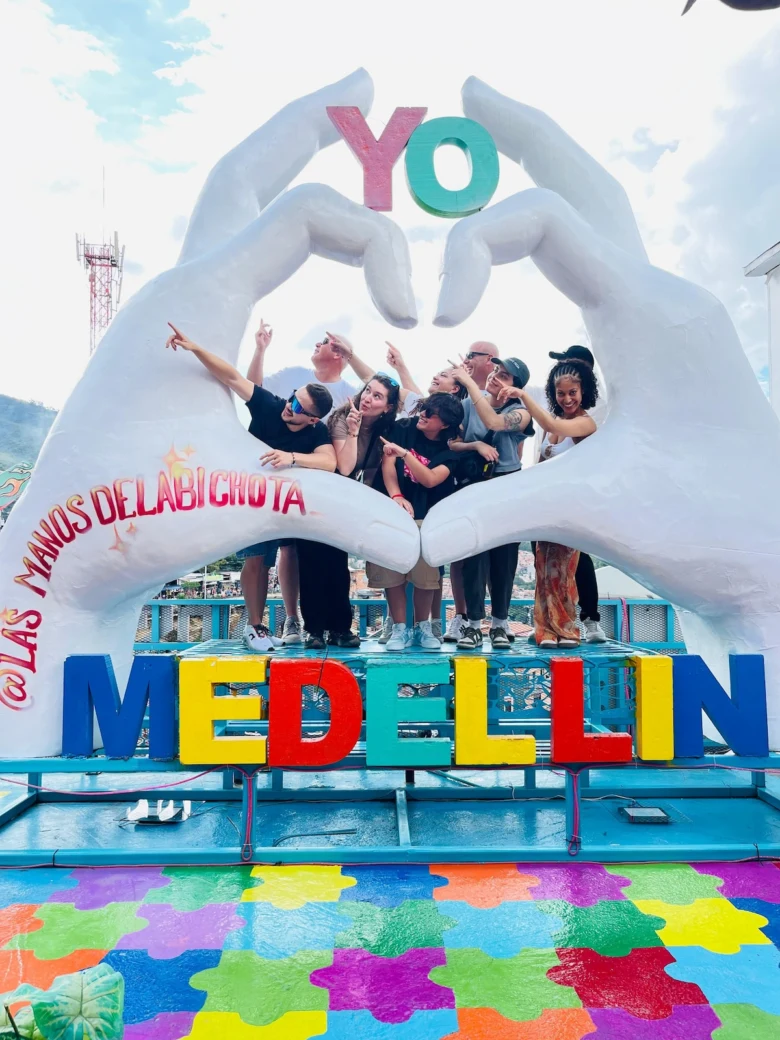 Skupina lidí v srdcovém otvoru rukou s nápisem Medellín.