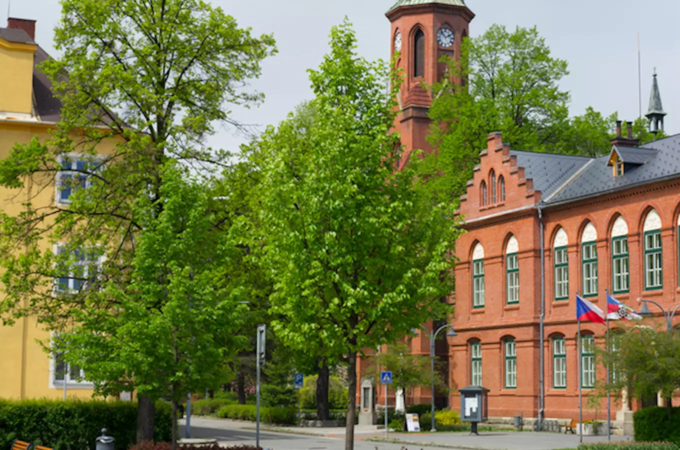 Red brick town hall with clock tower and flags in bohumín