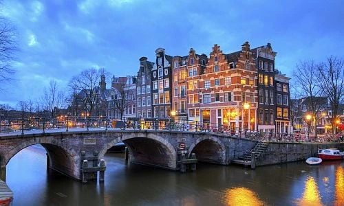 Historické domy v Amsterodamu s mostem nad kanálem.