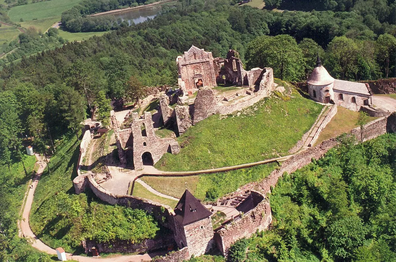 Zřícenina hradu Potštejn na kopci obklopená lesy