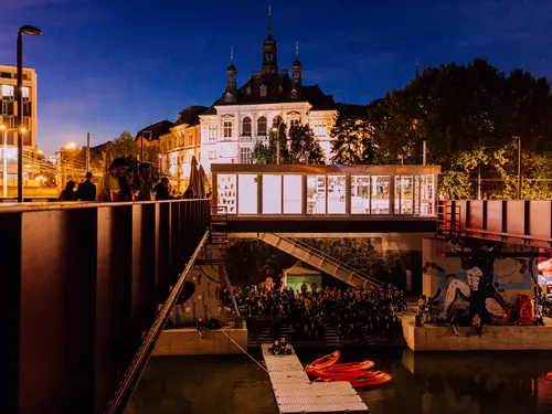Večerní kulturní akce na plzni s diváky a historickými budovami.