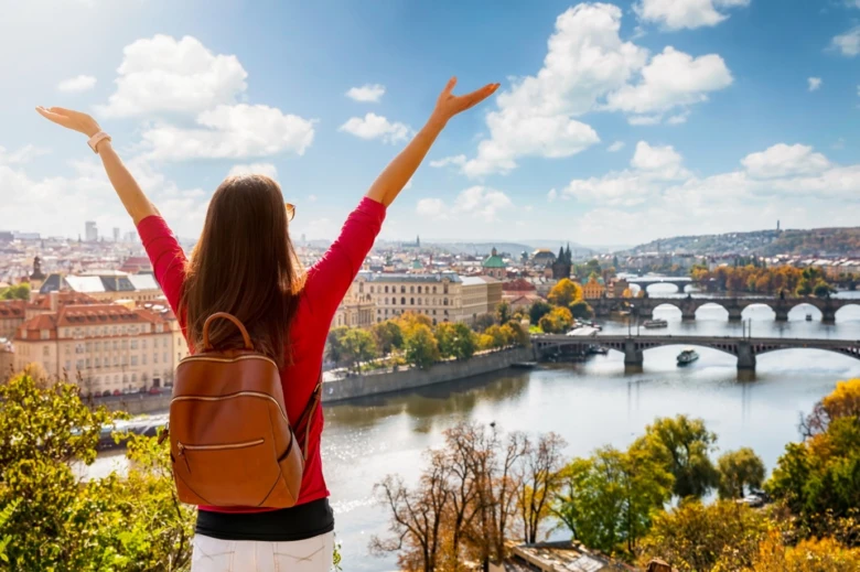 Žena s rozpažímí nad Prahou u řeky Vltavy