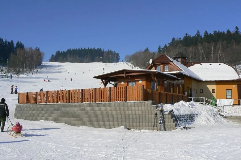 Dřevěná budova lyžařského střediska u sjezdovky v Olešnici.