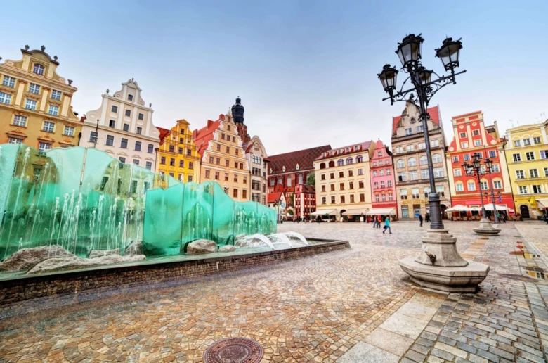 Fontána na náměstí ve Wrocławi s barevnými domy.