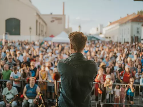 Hudebník vystupuje před davem na akci v Plzni.