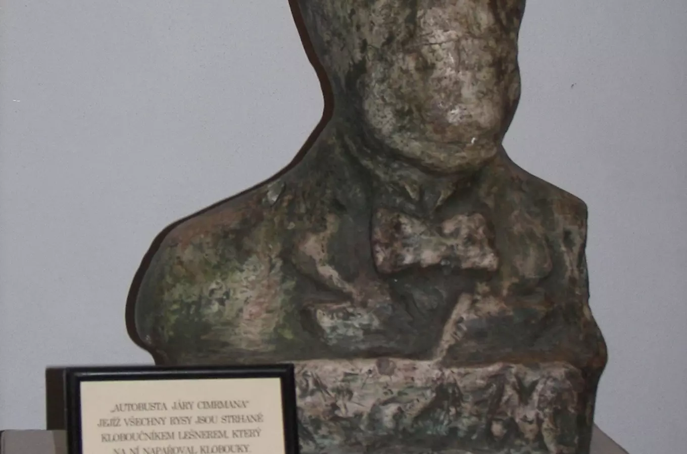 Bronzová socha Járy Cimrmanna s popisnou tabulkou.