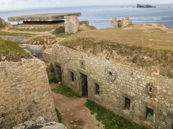 Staré kamenné pevnostní bunkry na skalnatém pobřeží Normandie.