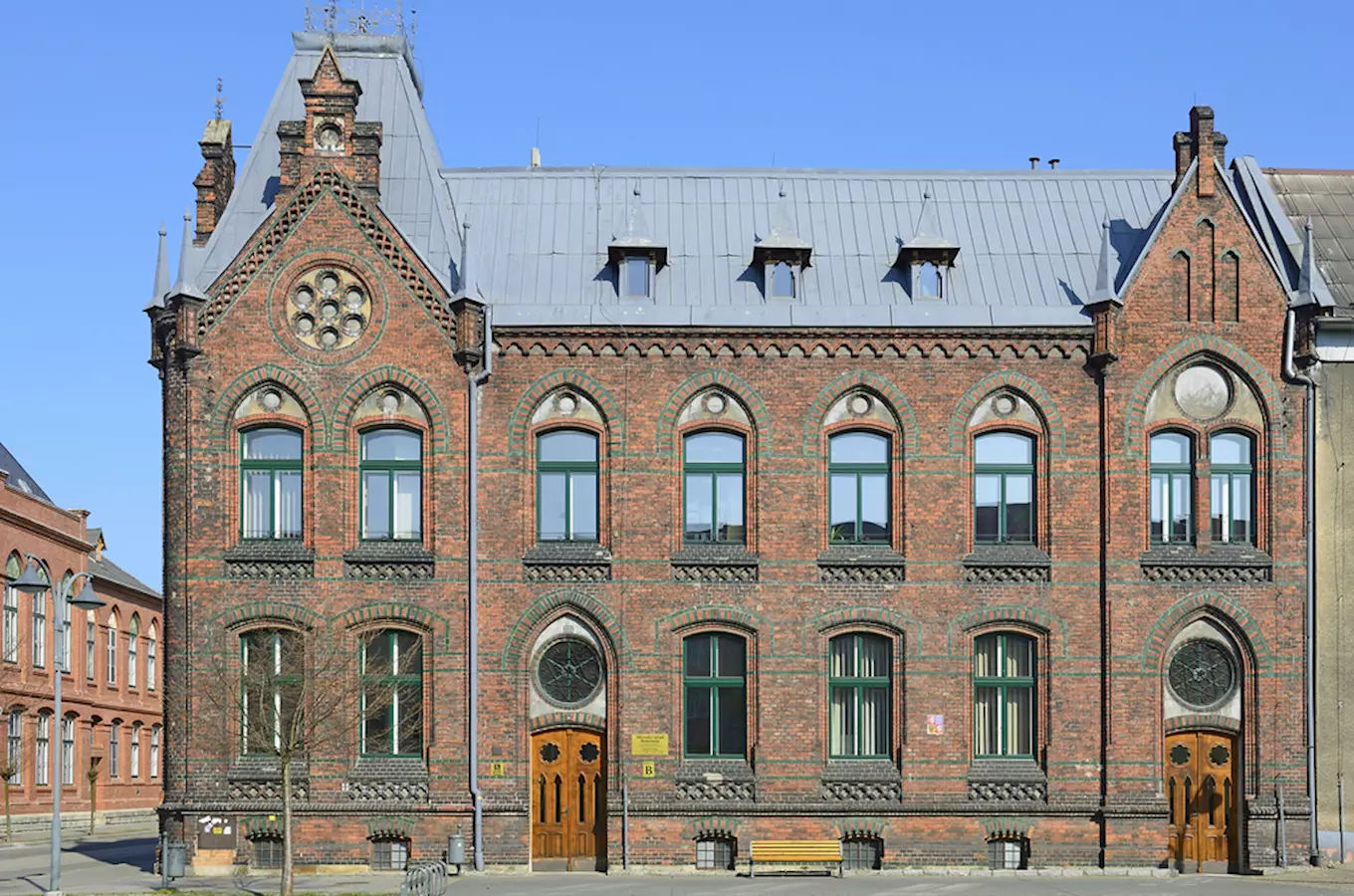 Historická budova v Bohumíně s červenými cihlami a obloukovými okny.