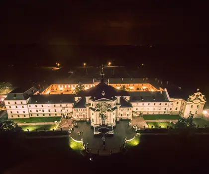 Noční pohled na zámek v Náchodě s osvětlenými zahradami.