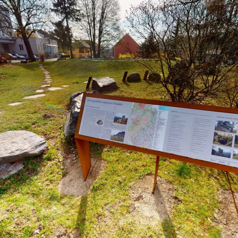 Informační tabule v parku s mapou a popiskem místa.
