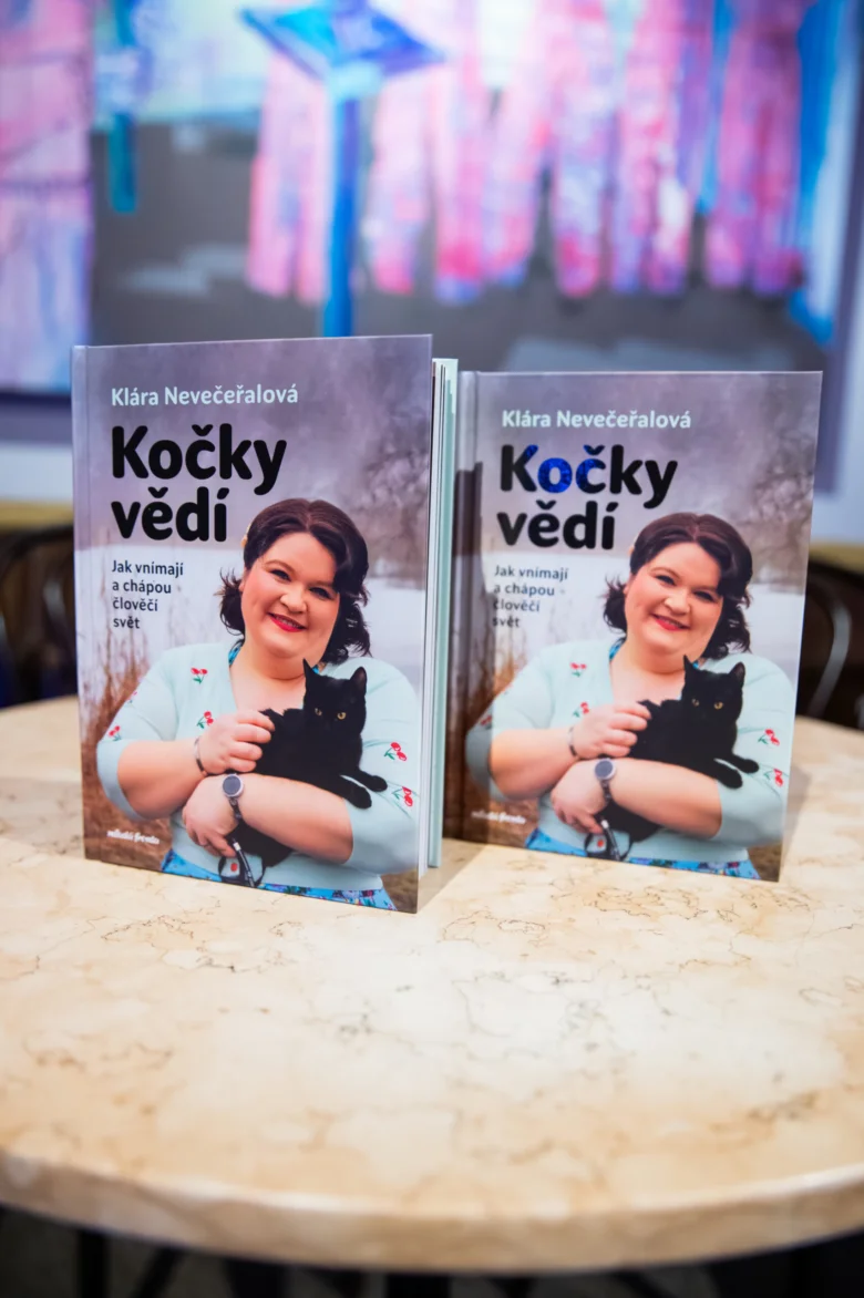 Dvě knihy s autorkou Klárou Nevečeřalovou na mramorovém stole.