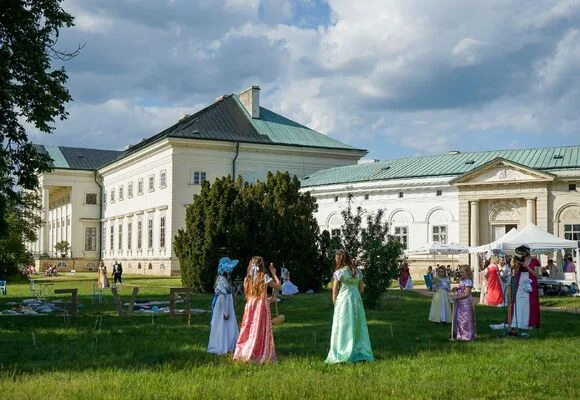 Lidé v historických kostýmech na nádvoří zámku během akce.
