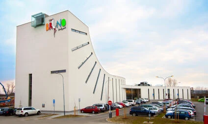 Exteriér zábavního centra Bruno v Brně s parkovištěm pro auta.