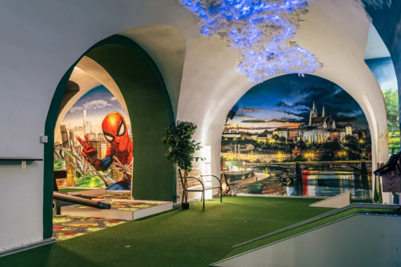 Indoor minigolf v Praze s motivy města a komiksových postav.