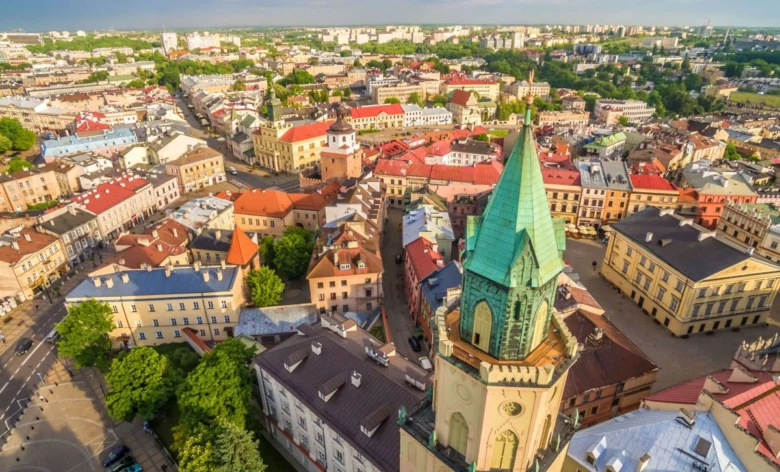 Pohled na polské město s kostelem a historickými střechami.