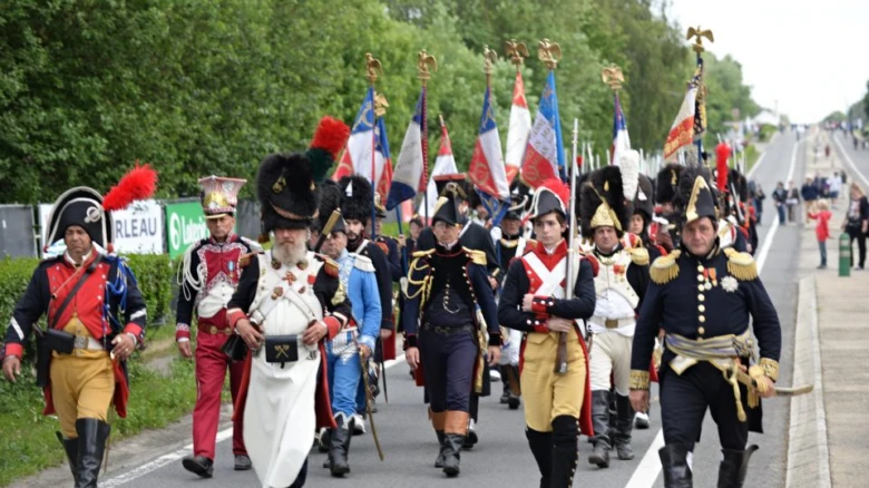 Reenactment bitvy u Waterloo s vojáky v historických uniformách.