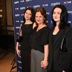 Kristýna Badinková s rodinou na akci před modrou stěnou.