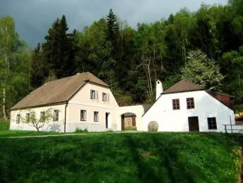 Tradiční domky v jižních Čechách uprostřed zelené přírody.