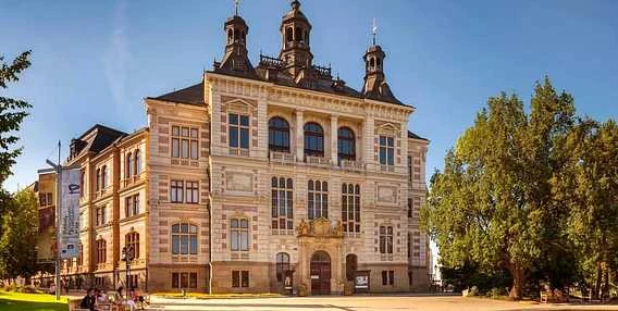 Historická budova s věžemi v Plzni na slunečný den.