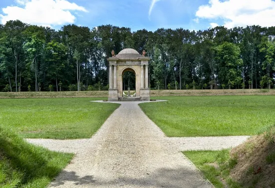 Pavilon v zahradě zámku Veltrušy s cestou a lesním pozadím.