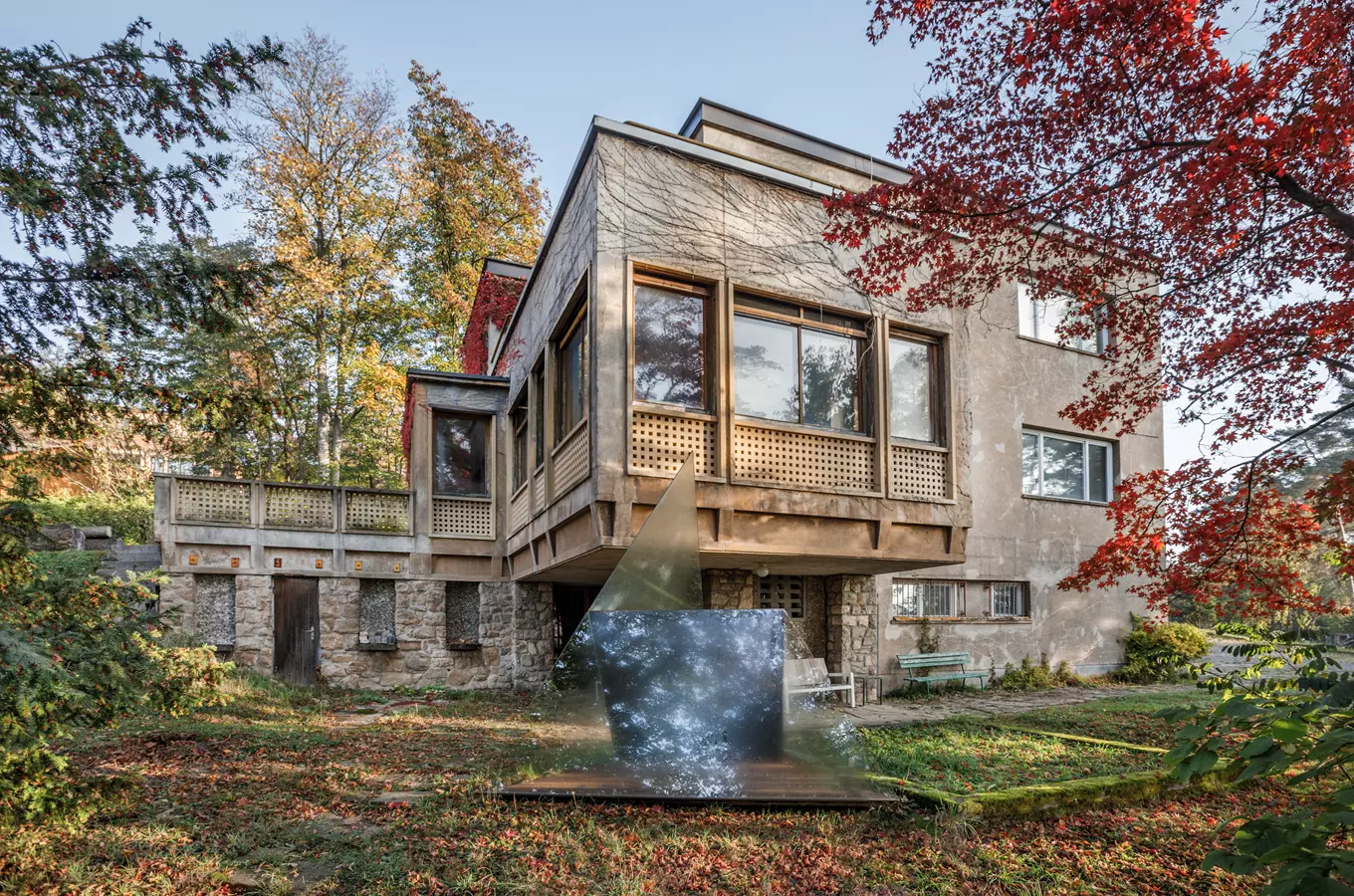 Exteriér Žikmundovy vily s výraznou architekturou a podzimní stromy.
