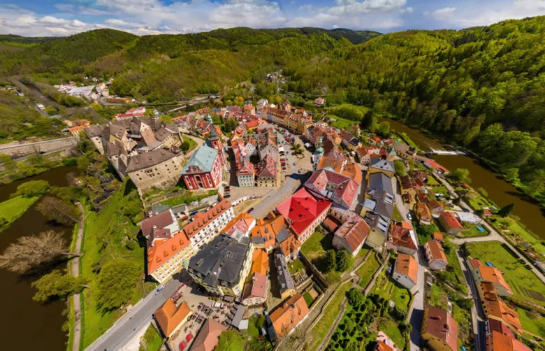 Vzdušný pohled na město Loket s řekou a okolními kopci.