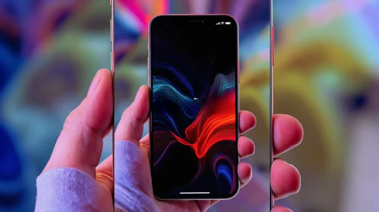 Ruka drží chytrý telefon s barevnou obrazovkou.