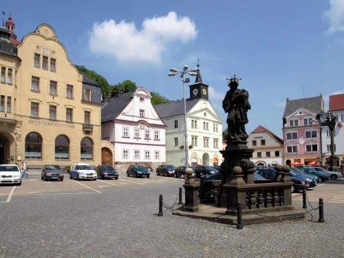 Náměstí v Náchodě s pomníkem a historickými domy.