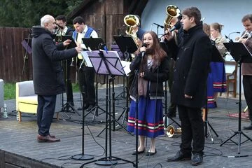 Bronzová kapela hraje na venkovním pódiu během kulturního programu.