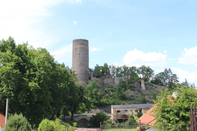 Zřícenina hradu na kopci s věží v příbramském okolí.