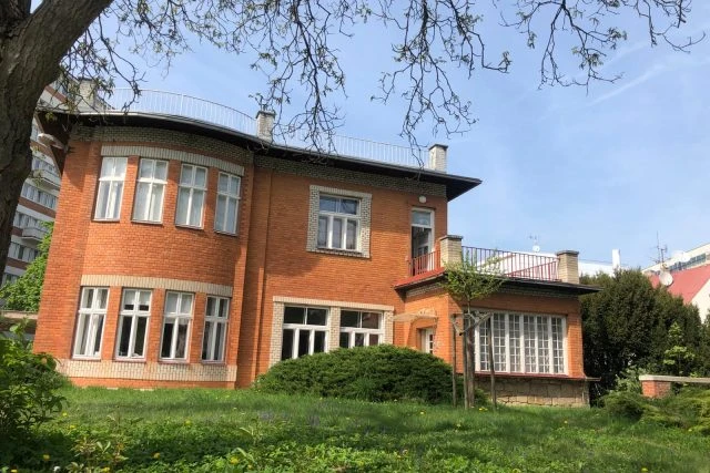 Červená cihlová vila Žikmundova s okny zahradou.