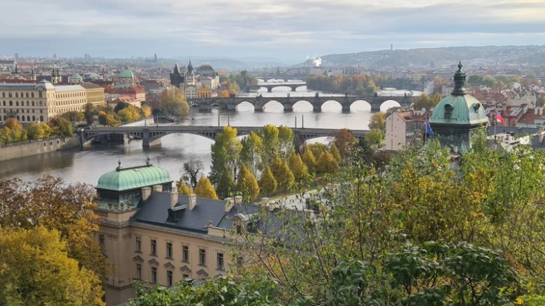 Pohled na Prahu s řekou Vltavou mosty a historickými budovami.