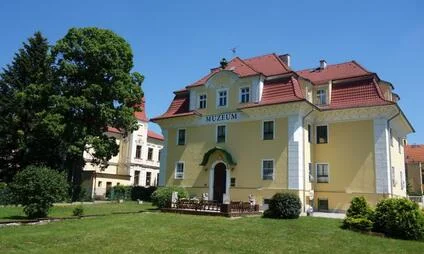Žlutá budova muzea s červenou střechou ve Františkových Lázních