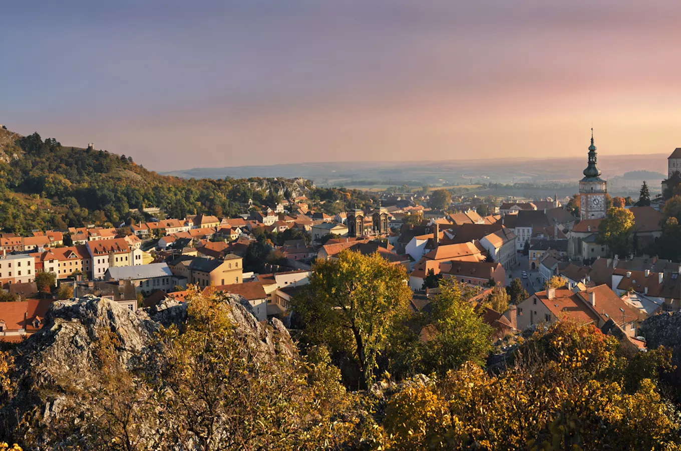 Pohled na městečko Mikulov s kostelem a hradem v podvečerním světle.