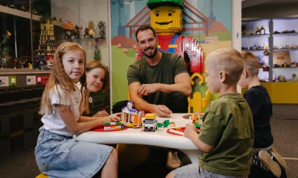 Rodina staví s Lego hračkami v herním centru.