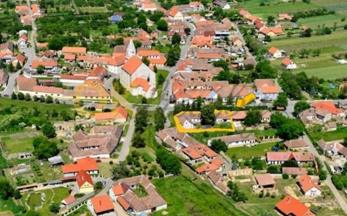 Vzdušný pohled na vesnici s vyraženými pozemky pro dražbu.