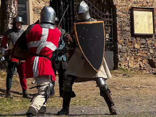 Dva bojovníci v historických zbrojích se střetávají na kulturním akce.