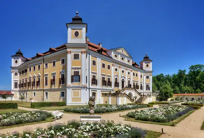 Zámek v Lednici s parkem na pozadí modrého nebe.