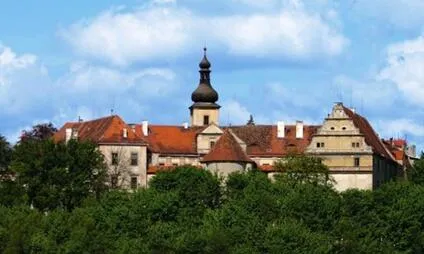 Historické centrum Mladé Boleslavi s kostelem na pozadí modré oblohy.